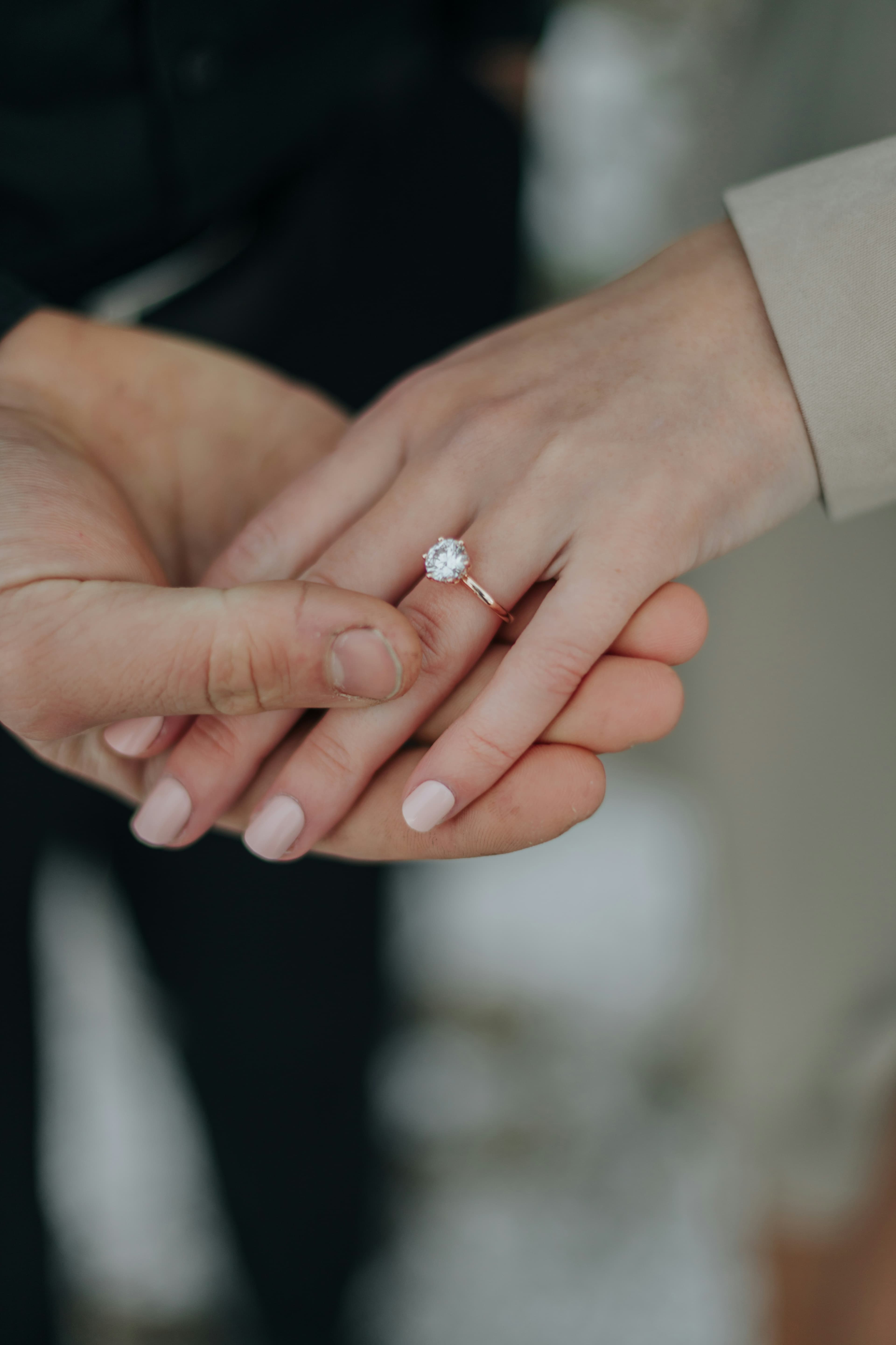 Engagement ring being placed on hand